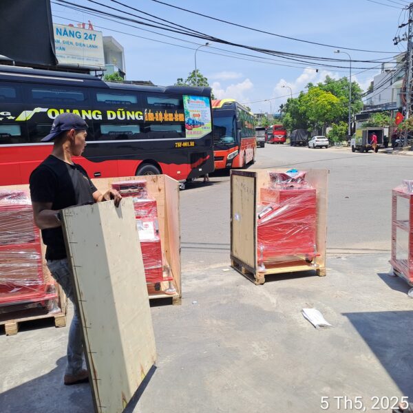 Công nhân mở thùng gỗ, thiết bị bọc màng co đặt trên pallet